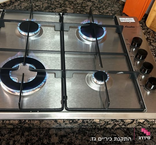כיריים גז עם ארבעה מבערים דולקים